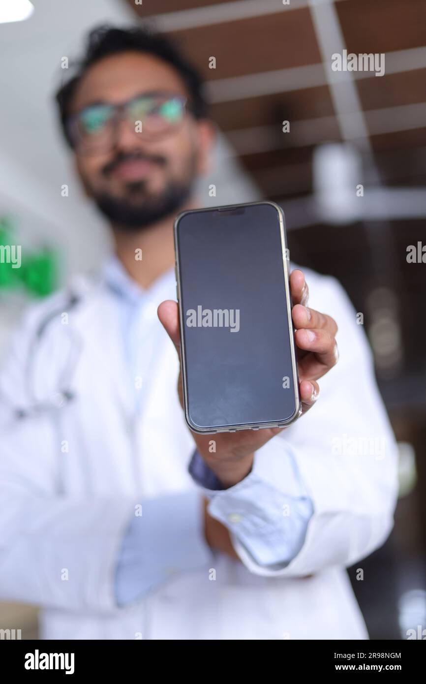 Arzt im Krankenhaus. Oberarzt mit Stethoskop im Klinikkorridor. Medizin, Personal, Gesundheitsfürsorge, Gesundheitsdienst. Speicherplatz kopieren. Mobile App wird angezeigt. Stockfoto