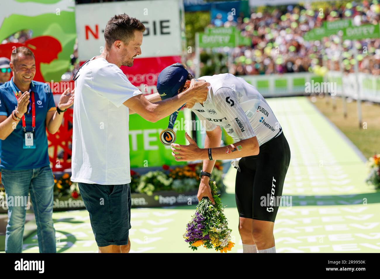 Roth, Deutschland. 25. Juni 2023. Triathlon: Challenge Roth, 3,86 km Schwimmen, 180,2 km Fahrrad, 42,2 km Laufen. Der dänische Magnus Ditlev (r), Gewinner des Herrenrenrenrenrenrenrenrenrennen bei der diesjährigen Triathlon Challenge Roth, erhält die Siegermedaille von Jan Frodeno. Kredit: Daniel Löb/dpa/Alamy Live News Stockfoto