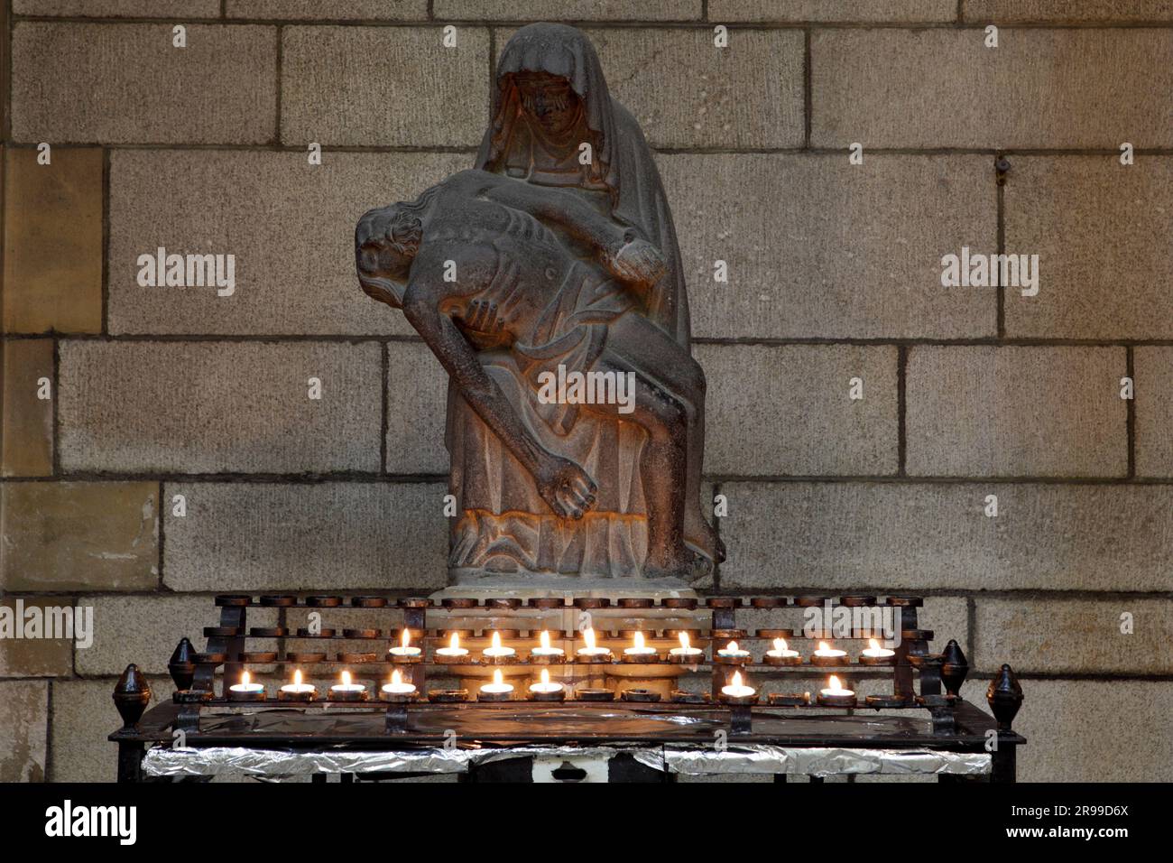 Eine Statue der Jungfrau Maria und Jesu Christi. Zünden Sie eine Kerze an, um sich zu erinnern. Stockfoto