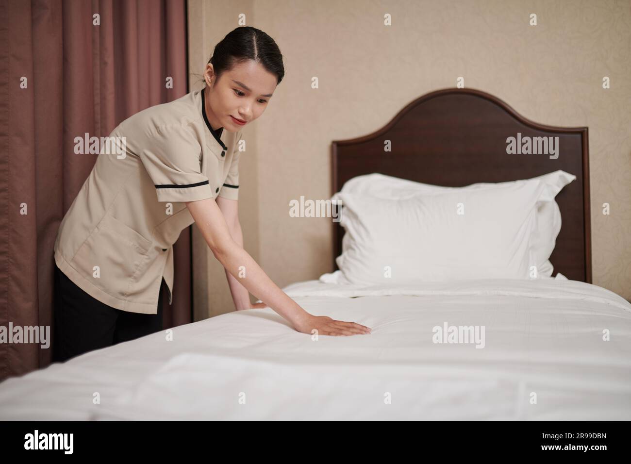 Das Zimmermädchen wechselte die Bettwäsche und machte das Bett für neue Gäste Stockfoto