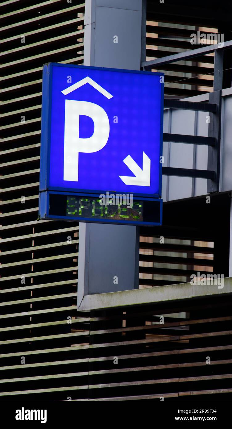 Beleuchtetes Parkplatzschild am mehrstöckigen Gebäude Stockfoto