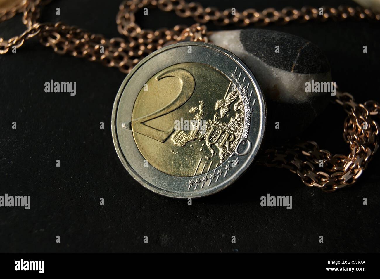 2-Euro-Münze und Goldkette. Münzen und Schmuck. Stockfoto