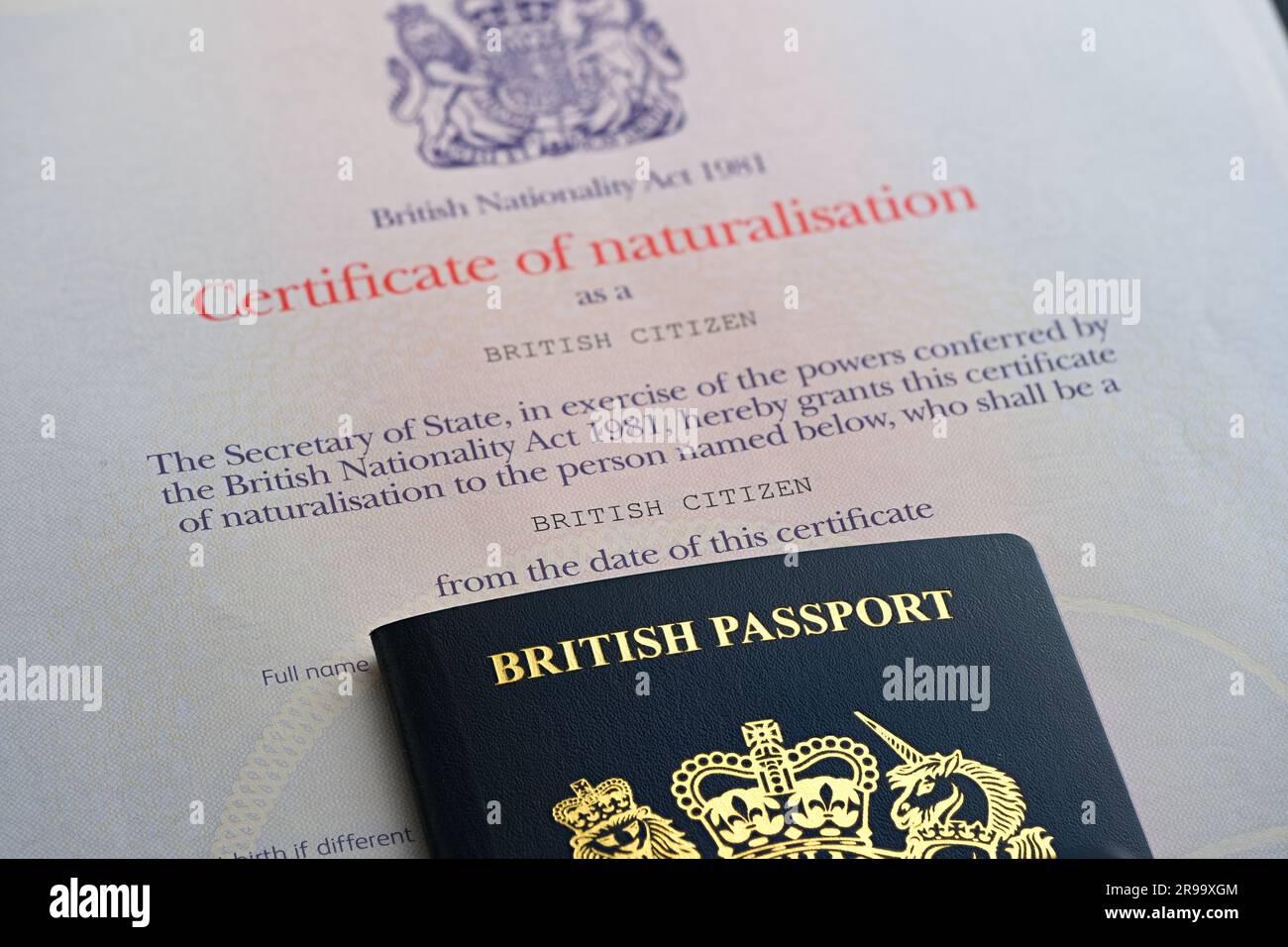 Britischer Reisepass zusätzlich zum Einbürgerungszertifikat als britischer Staatsbürger. Stafford, Großbritannien, 25. Juni 2023 Stockfoto