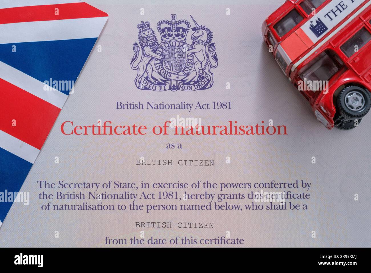 Die britische Flagge und der Doppeldeckerbus werden auf dem authentischen Staatsbürgerschaftszeugnis platziert. Einbürgerungsnachweis als britischer Staatsbürger. Stafford, Vereint Stockfoto