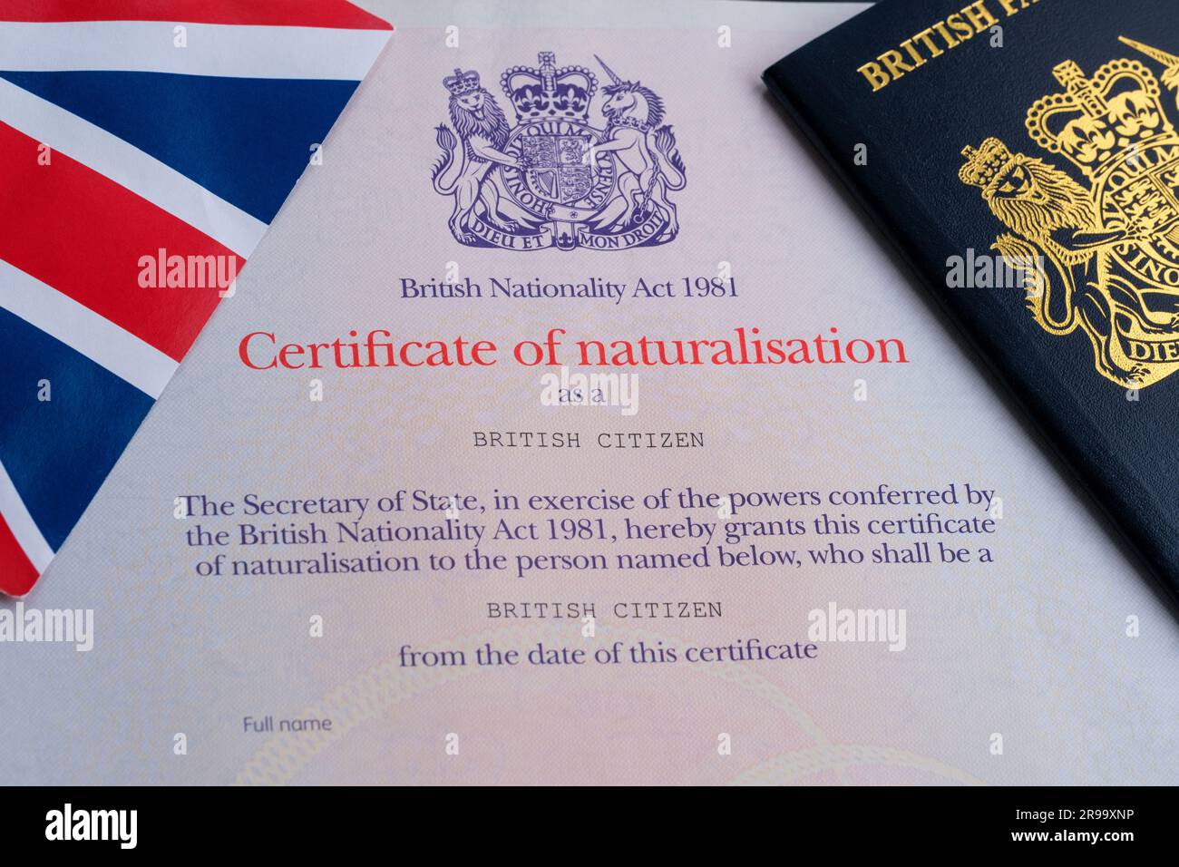 Britische Flagge und Reisepassspitze des Zertifikats der authentischen Staatsbürgerschaft. Einbürgerungsnachweis als britischer Staatsbürger. Stafford, Vereinigtes Königreich, Juni 25, Stockfoto