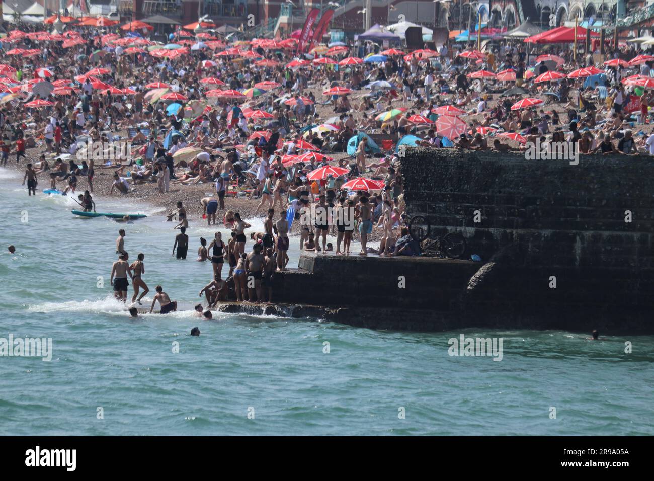 Brighton Beach war dieses Wochenende ein Haufen Aktivität, da die glühenden Temperaturen bei 24 °C zur Mittagszeit ihren Höhepunkt erreichten und Horden von Sonnensuchern an die Küste zogen. Das einladende Meer mit seiner Kühltemperatur von 17,2 °C bot eine dringend benötigte Erholung von der Hitze. Stockfoto