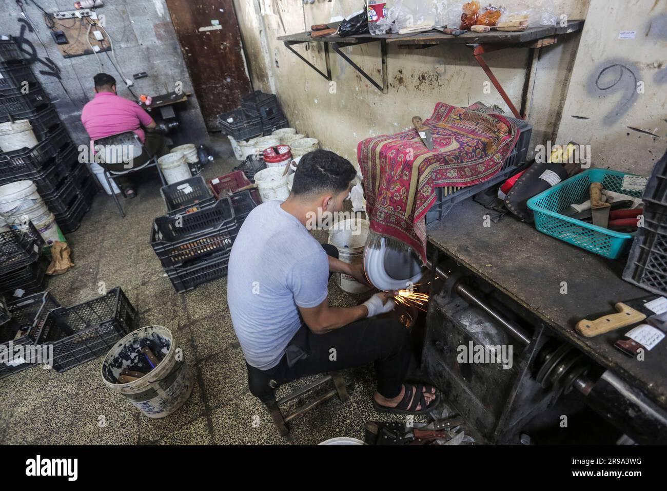 25. Juni 2023, Gaza-Stadt, Gaza-Streifen, Palästina: Palästinensische Männer schärfen Messer, die während des Eid al-Adha zum Schlachten von Opfertieren östlich von Gaza-Stadt verwendet werden. (Kreditbild: © Mahmoud Issa/Quds Net News via ZUMA Press Wire) NUR REDAKTIONELLE VERWENDUNG! Nicht für den kommerziellen GEBRAUCH! Stockfoto