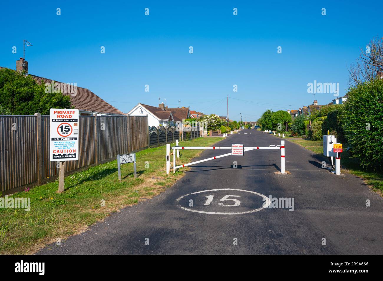Eingezäunter Eingang mit geschlossenem Tor zu einer privaten Straße mit 15MPH Geschwindigkeitsbegrenzung an der Cudlow Avenue, Rustington, West Sussex, England, Großbritannien. Stockfoto