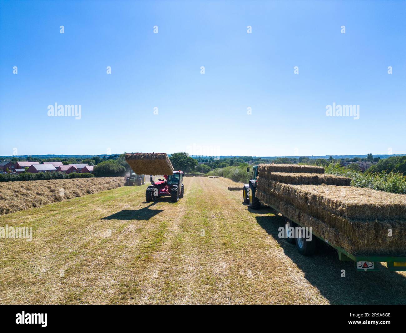 Heuernte mit Ballengreifer von Landmaschinen im Sommer, Draufsicht. Stockfoto