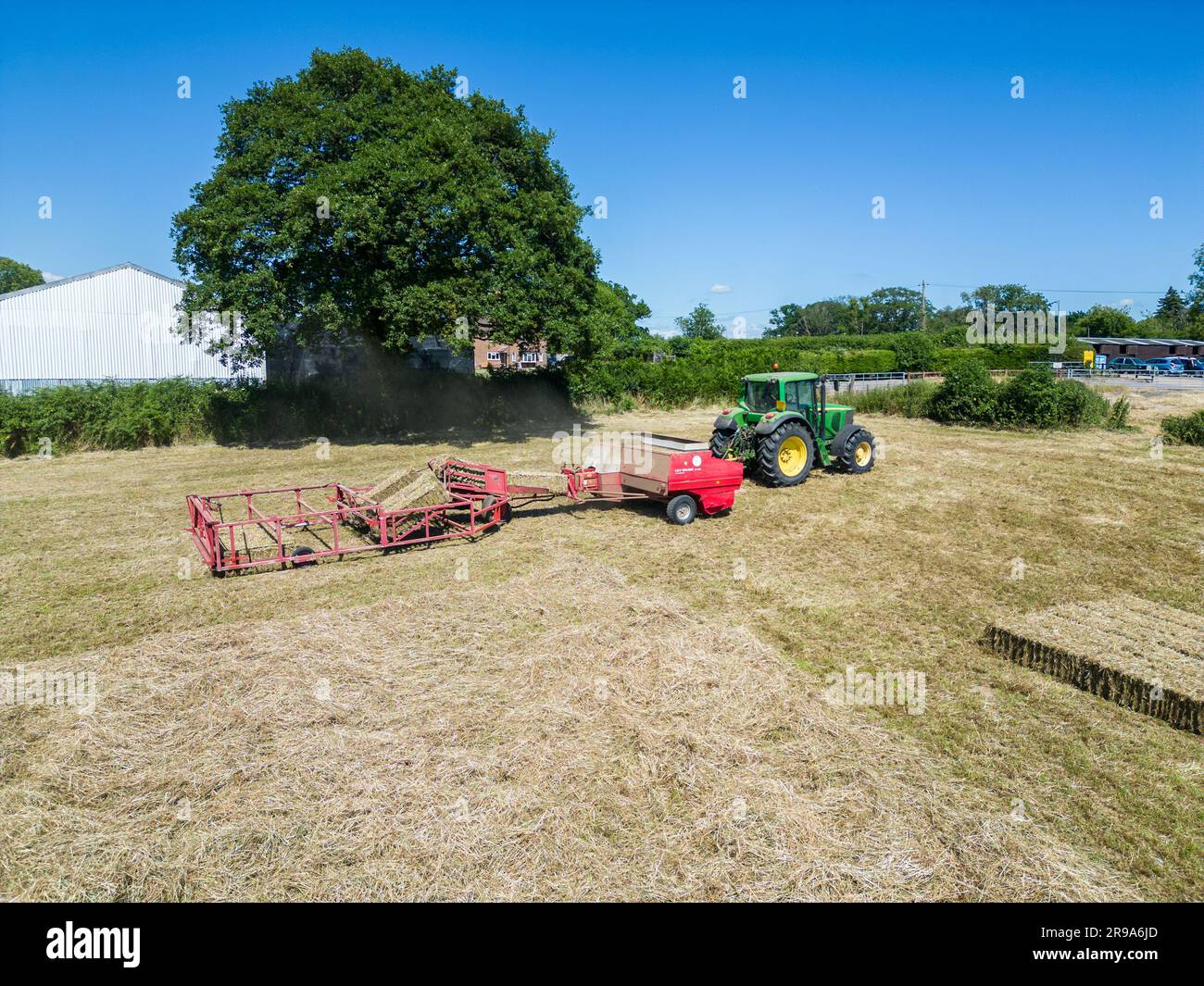 Heuernte mit Ballengreifer von Landmaschinen im Sommer, Draufsicht. Stockfoto