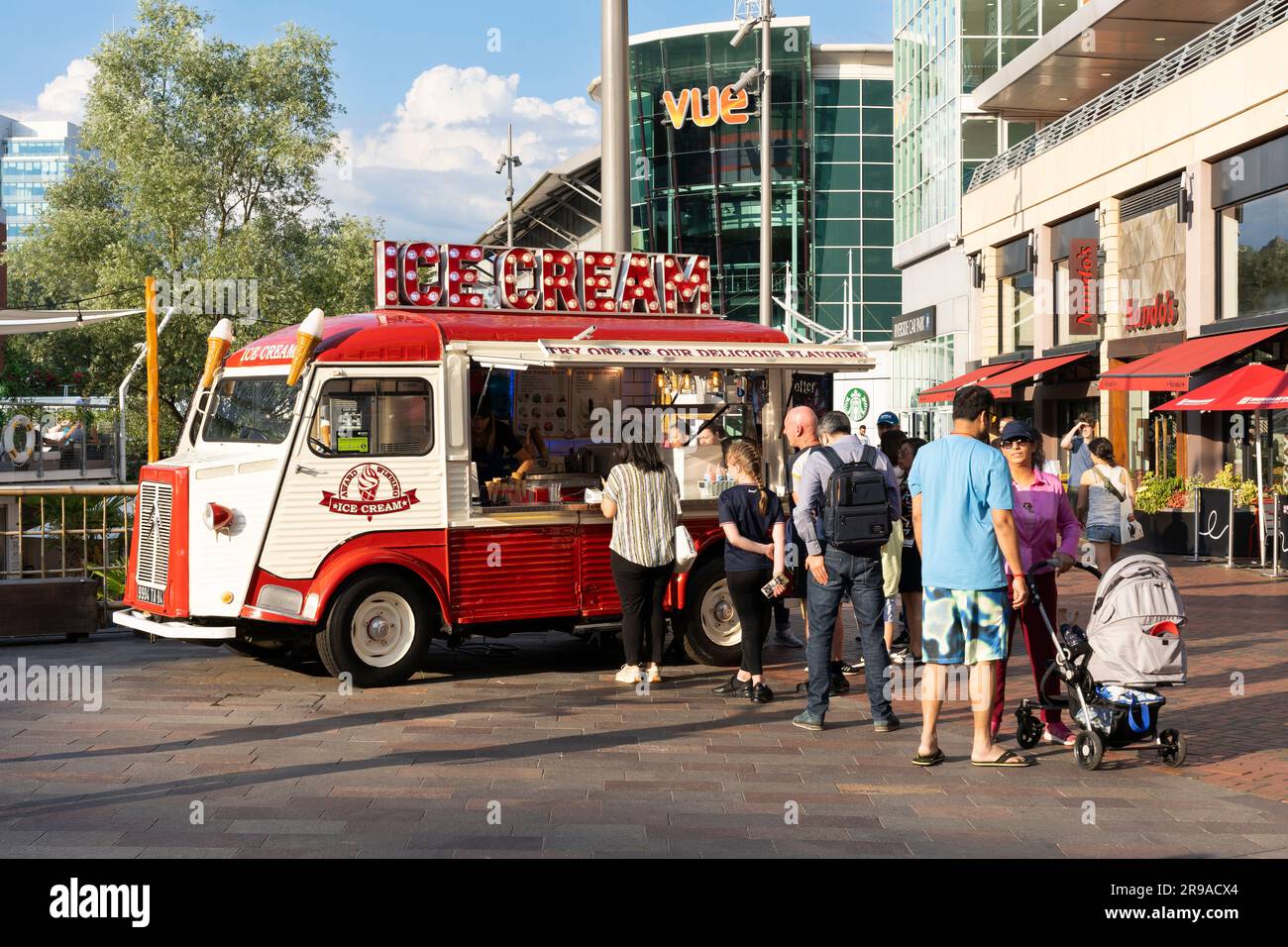 An einem heißen Sommertag am Oracle Riverside neben dem River Kennet stehen Leute in der Schlange, um preisgekröntes Eis aus einem Eiswagen zu bekommen. Reading, UK Stockfoto