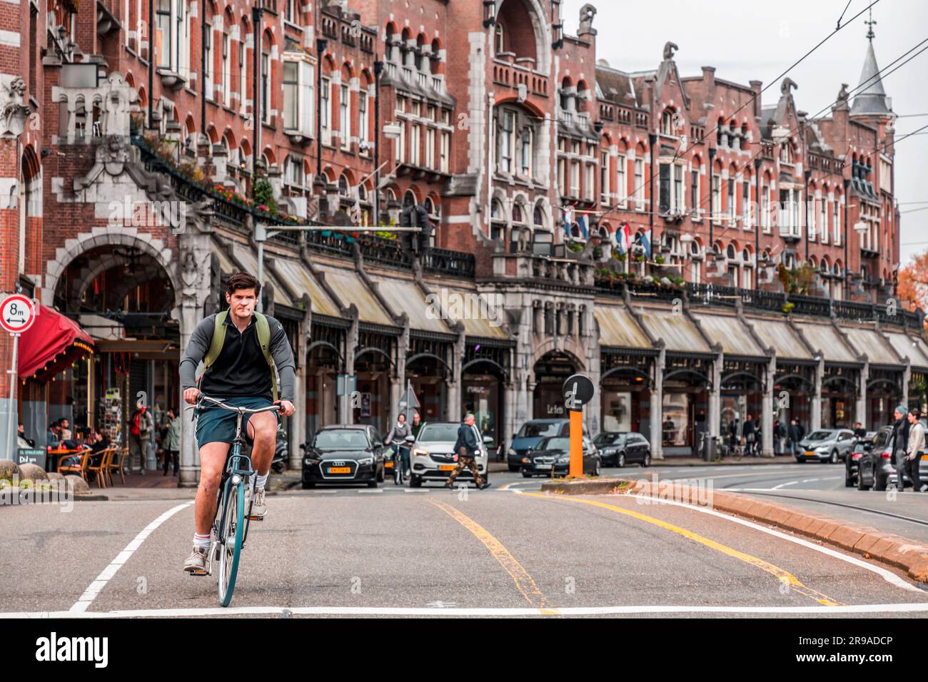 Amsterdam, Niederlande - 17. Oktober 2021: Unidentifizierter junger Mann auf einem Fahrrad in den Straßen Amsterdams. Radfahren ist die wichtigste Art des Transports Stockfoto