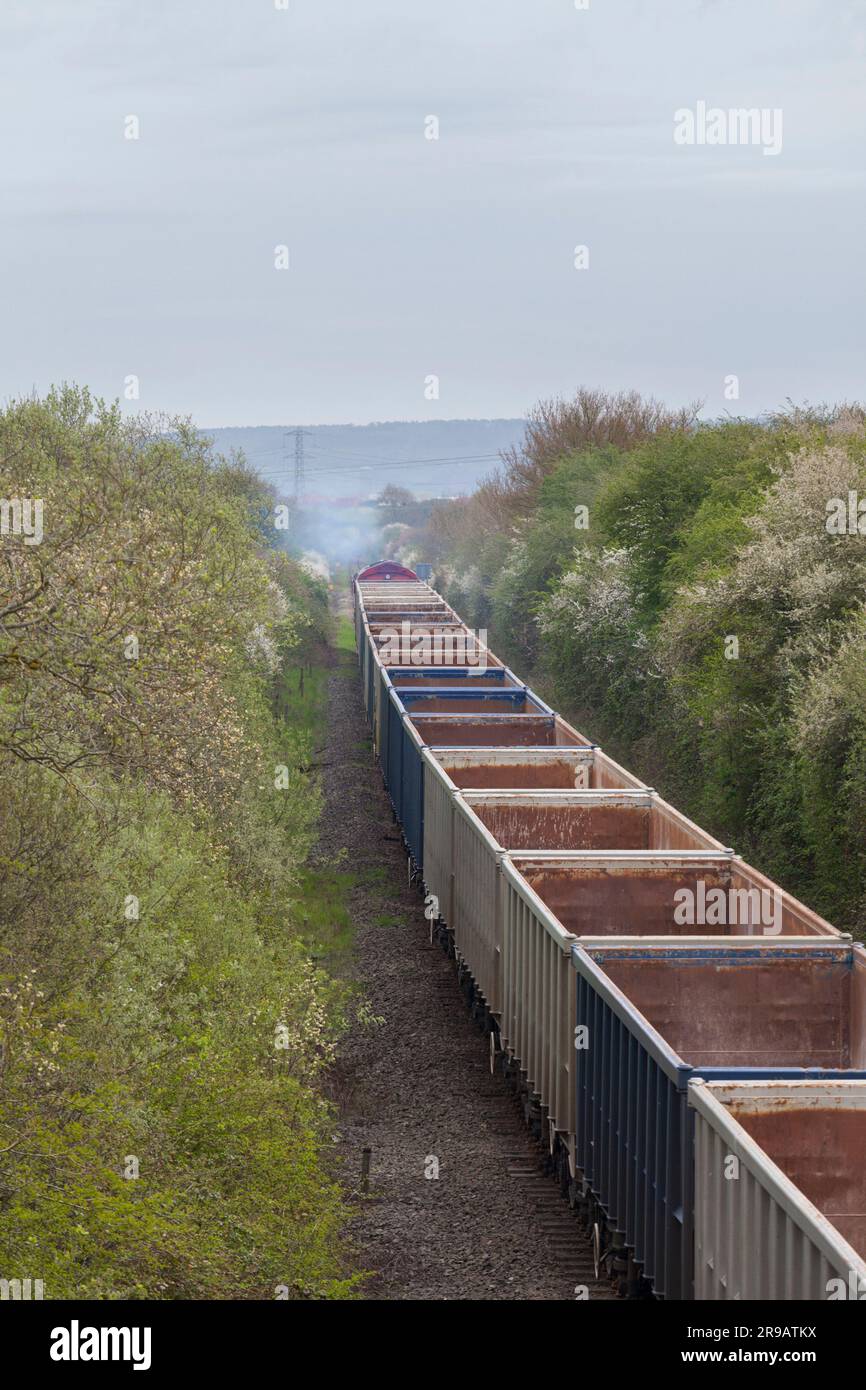 DB Cargo Rail UK-Diesellokomotive der Klasse 66, die einen Zug leerer Zuschlagwagen vom HS2-Bauterminal am Quainton-Eisenbahnkopf wegtransportiert Stockfoto