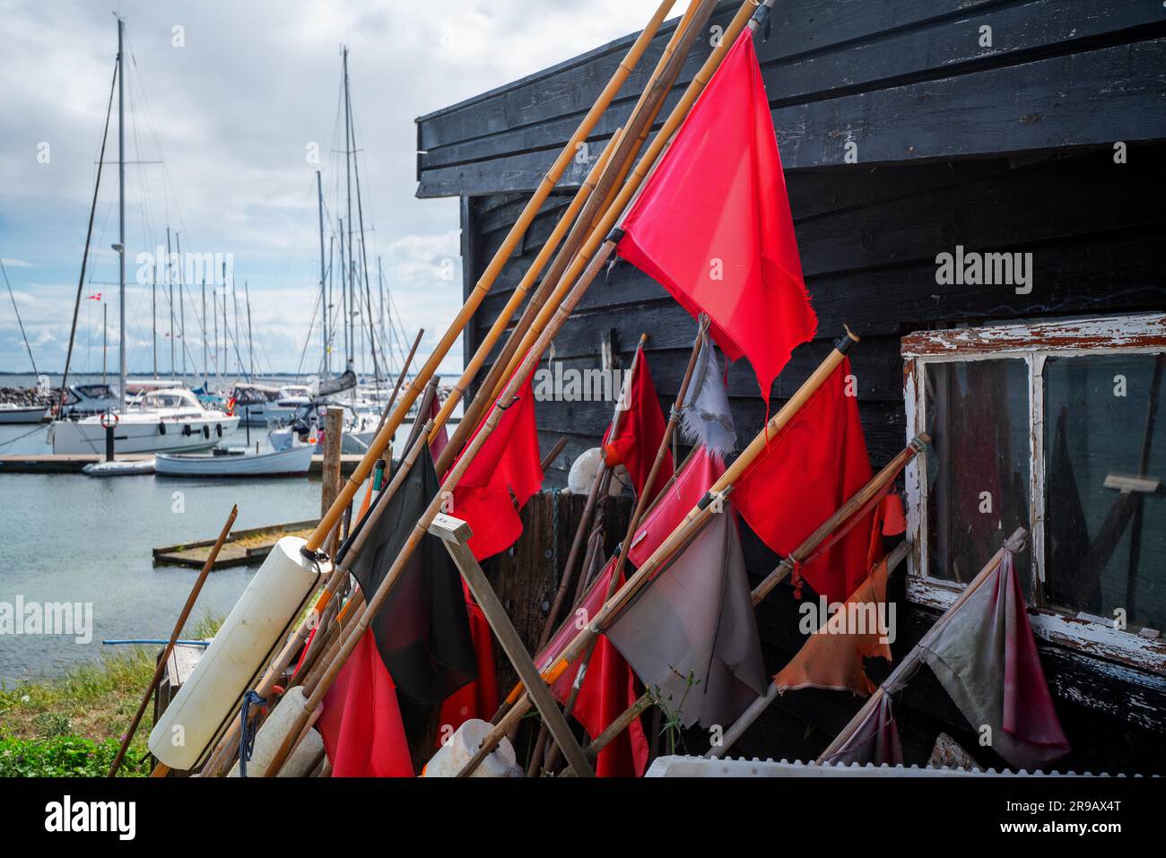 Rote Signalfahnen an einem Seehafen mit Segelbooten Im Hintergrund Stockfoto