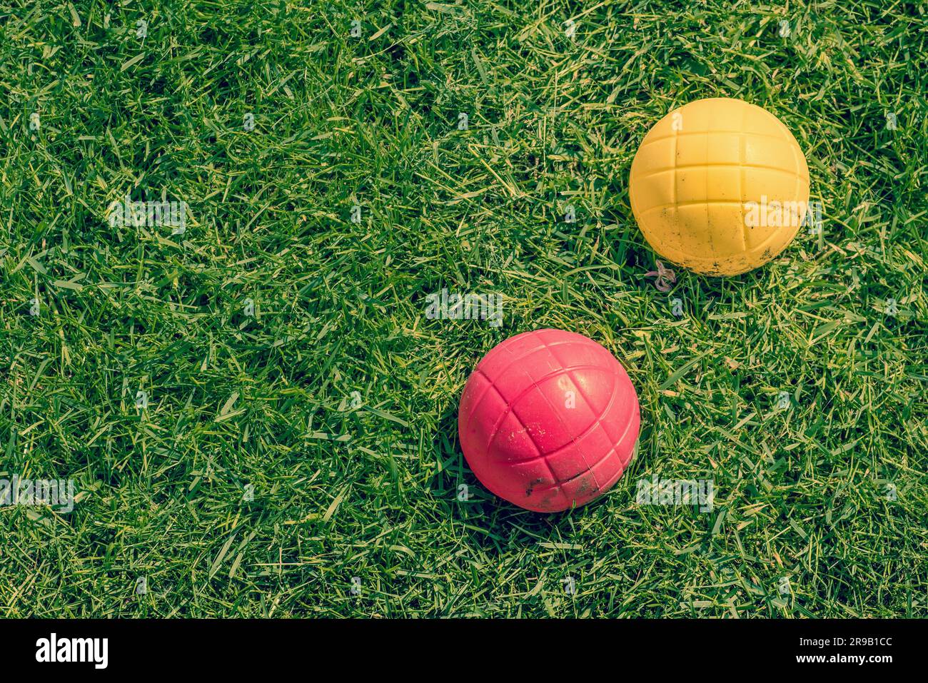 Rote und gelbe Kugel aus einem Garten Boccia-Spiel auf dem Rasen Stockfoto