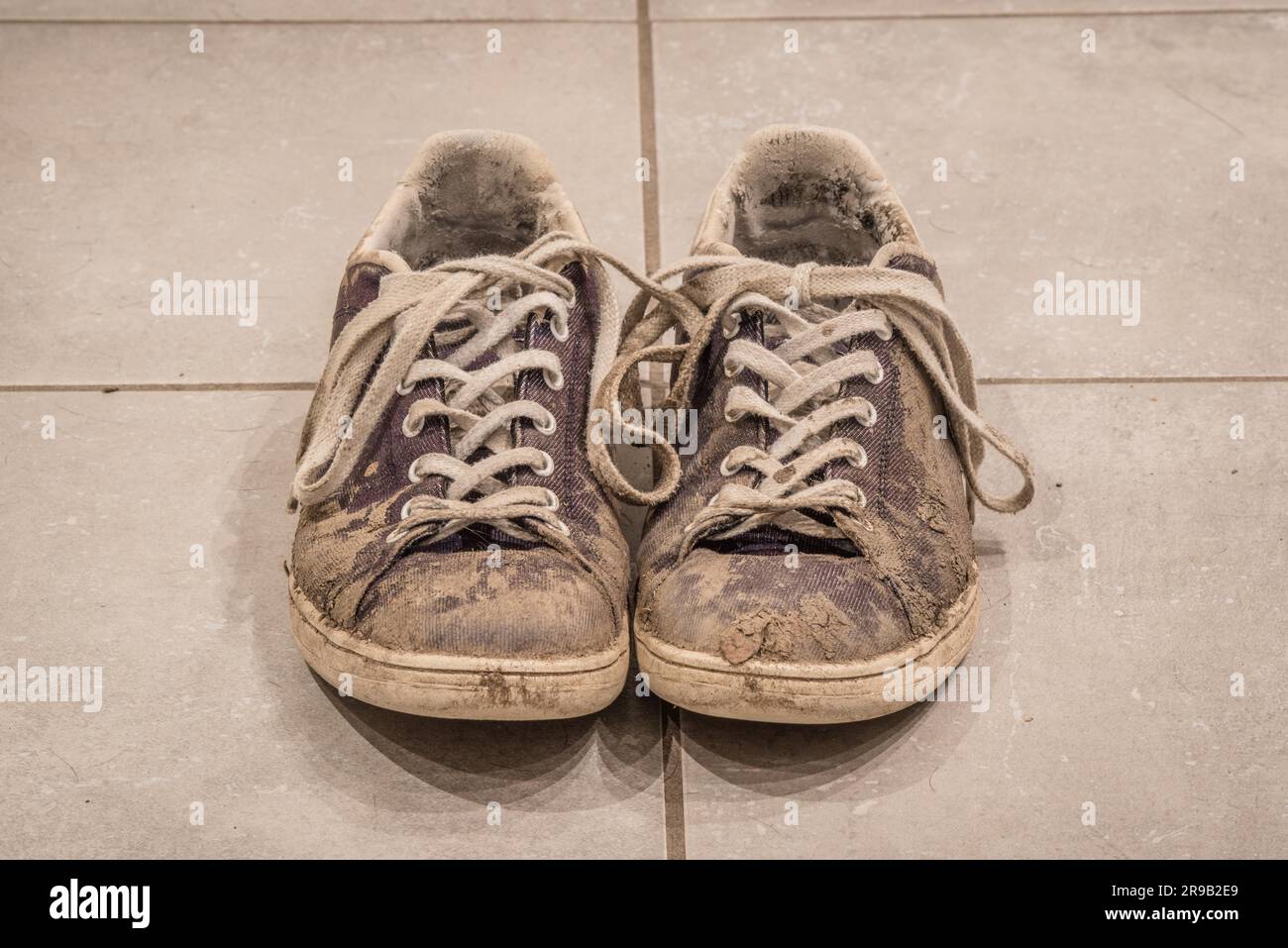 Schmutzige Schuhe mit Schlamm auf dem Boden Stockfoto
