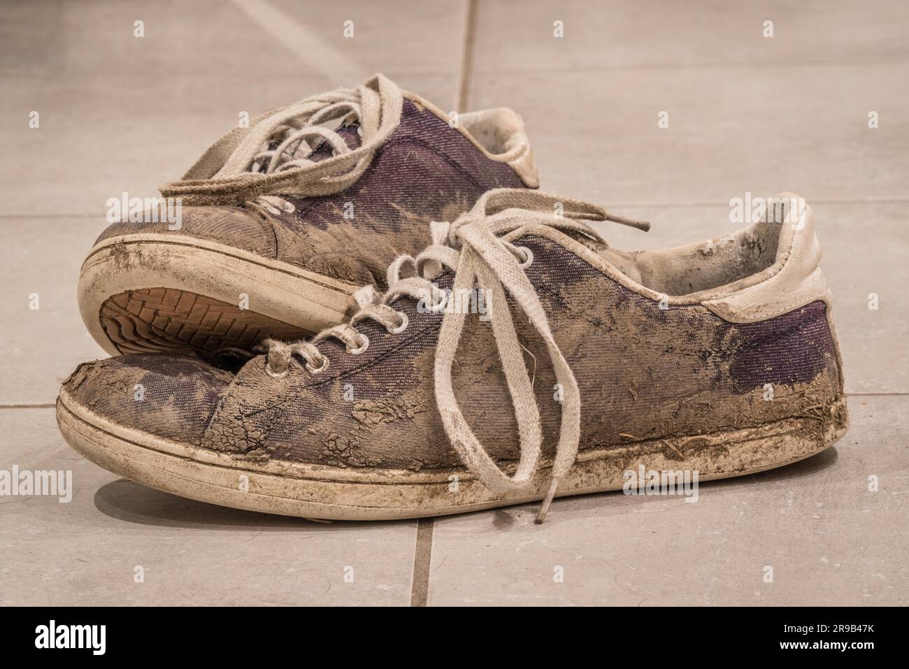 Schmutzige Schuhe mit Schlamm und Erde auf einer Etage Stockfoto