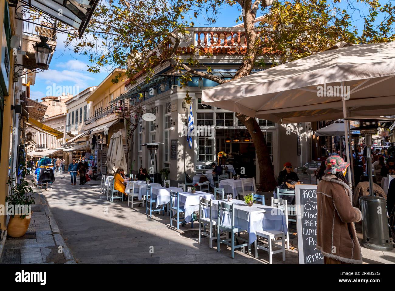 Athen, Griechenland - 25. November 2021: Sitzplätze im Freien in den traditionellen griechischen Restaurants in den zentralen Straßen von Athen, Griechenland. Stockfoto