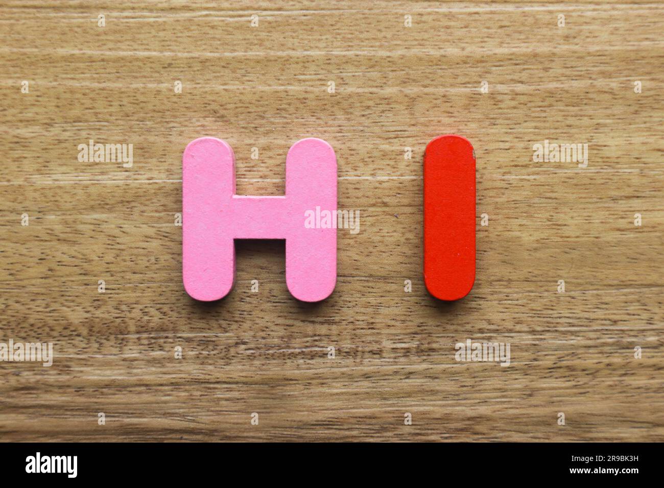 Die Buchstaben aus Holz bilden ein Wort „Hi“. Stockfoto