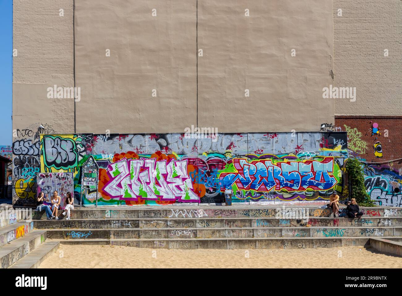 Berlin, Deutschland - 1. Juni 2023: Touristen, die kostenlose öffentliche urbane Kunst der East Side Gallery in einer öffentlichen Straße in Berlin besuchen Stockfoto