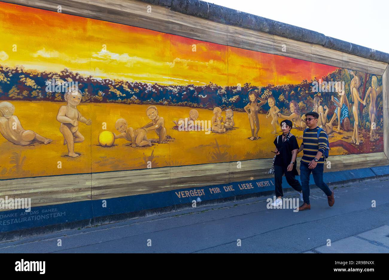 Berlin, Deutschland - 1. Juni 2023: Besucher der kostenlosen öffentlichen städtischen Kunst der East Side Gallery an der öffentlichen Straße in Berlin Stockfoto