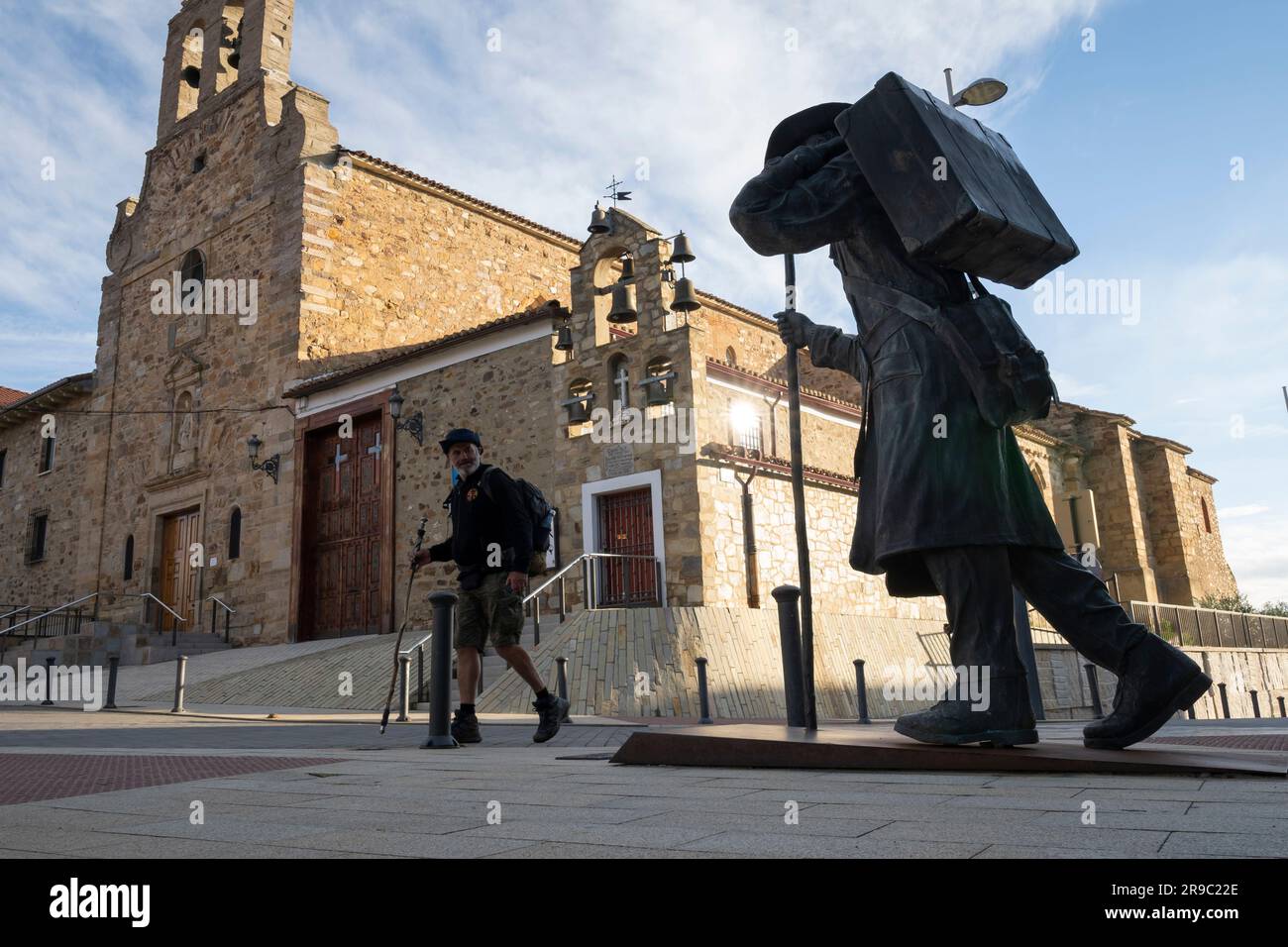 Ein Pilger auf dem Camino Frances blickt auf die Statue eines Pilgers in der Albergue de peregrinos Siervas de María, wenn er in Astorga, Spanien ankommt. Diese Anci Stockfoto