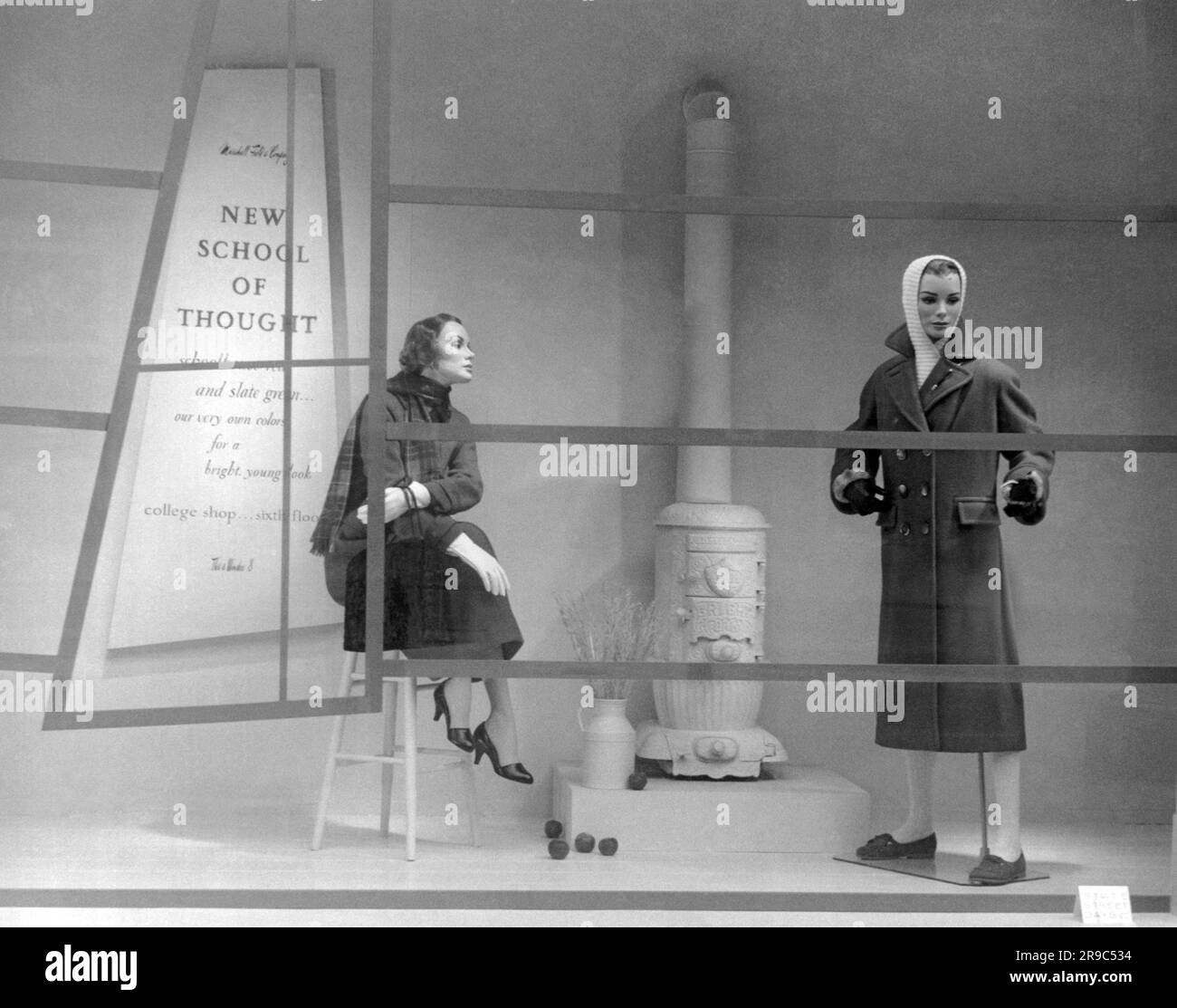 Chicago, Illinois: 11. August 1956 Ein Schaufensterbummel im Kaufhaus von Marshall Field während der State Street Days, in dem die „New School of Think“ für College-Käufer im Vergleich zu den vergangenen Tagen gezeigt wird, wie der alte Kohlewärmer beweist. Stockfoto