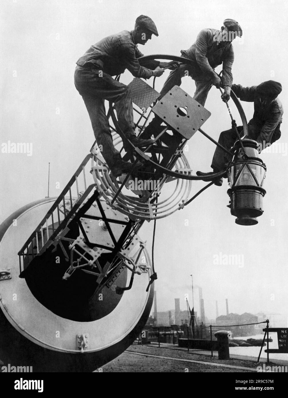 England: 13. Oktober 1923 Arbeiter, die eine der neuen 900 Kerzen Strom Petroleumdampflampen an eine Küstenboje montieren. Sie sind doppelt so hell wie die alten Paraffinlampen. Stockfoto