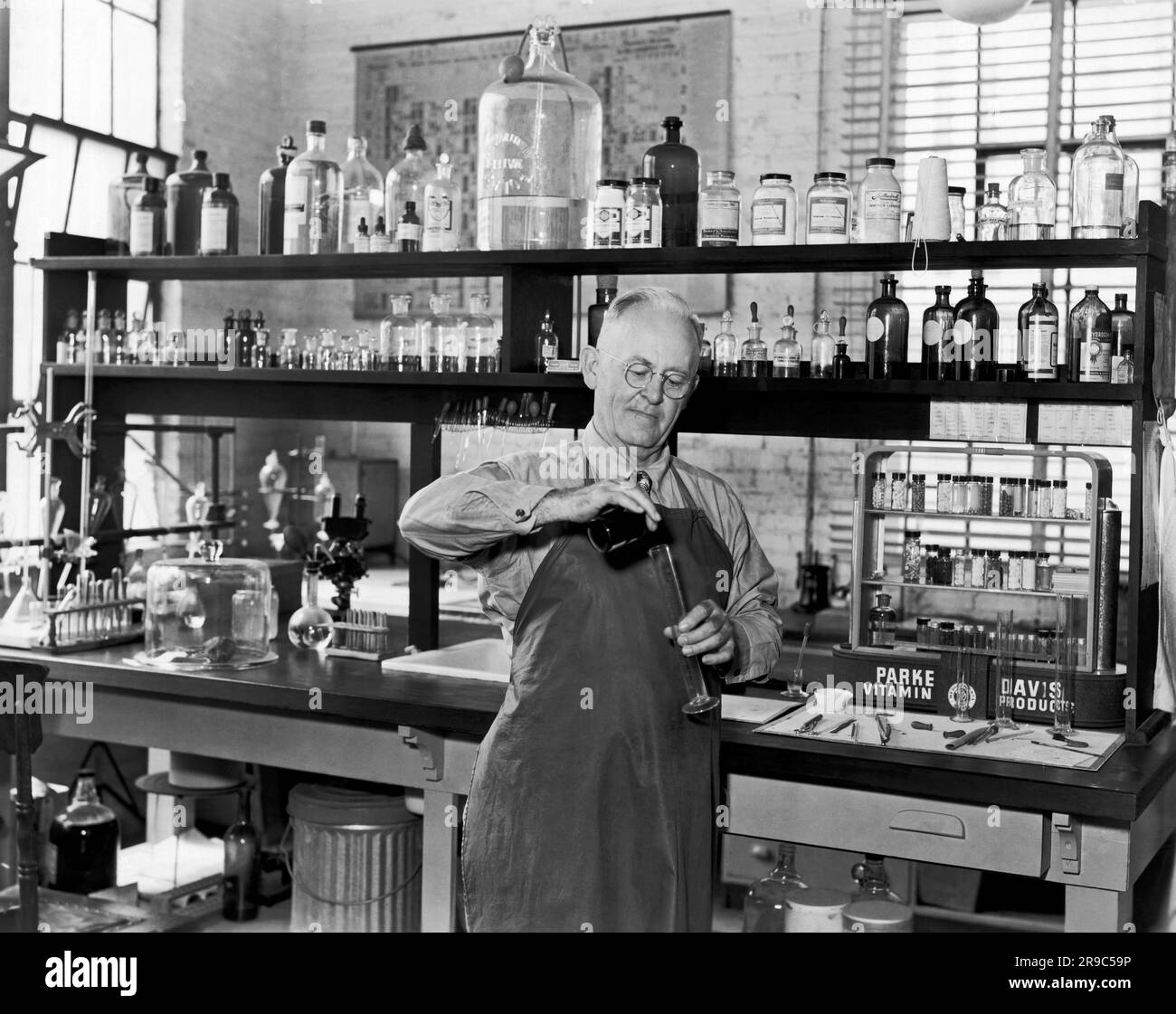 USA: c. 1948 Ein Chemiker, der in einem Labor mit Parke Davis Vitaminprodukten arbeitet, wird auf dem Tisch angezeigt. Stockfoto