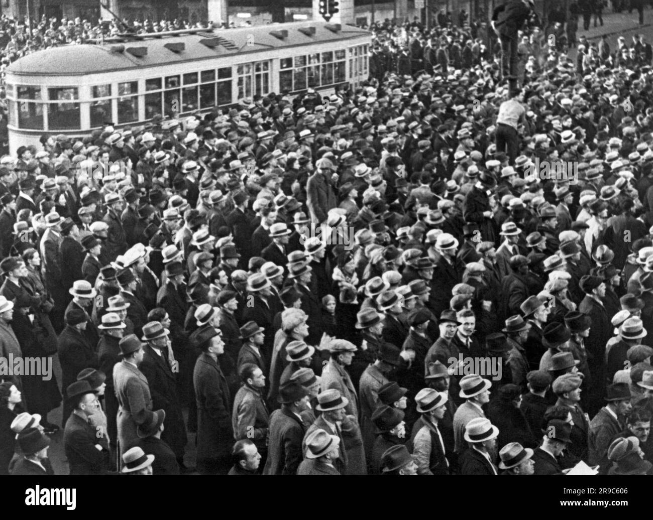 Detroit, Michigan: 1936 Teil der Menge von 100.000 Gewerkschaftsarbeitern versammelten sich am Cadillac Square, um gegen gerichtliche Anordnung die Räumung der Stürmer zu demonstrieren. Eine Straßenbahn wird bei der Demonstration erwischt. Stockfoto