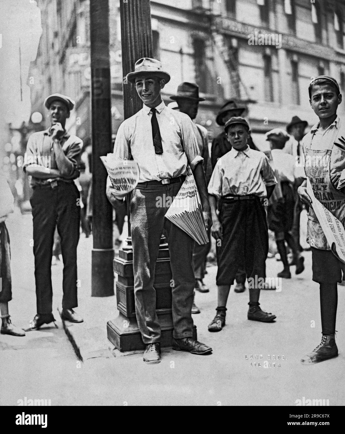 Atlanta, Georgia: ca. 1920 Ein junger Mann, der Zeitungen an der Straßenecke verkauft. Stockfoto