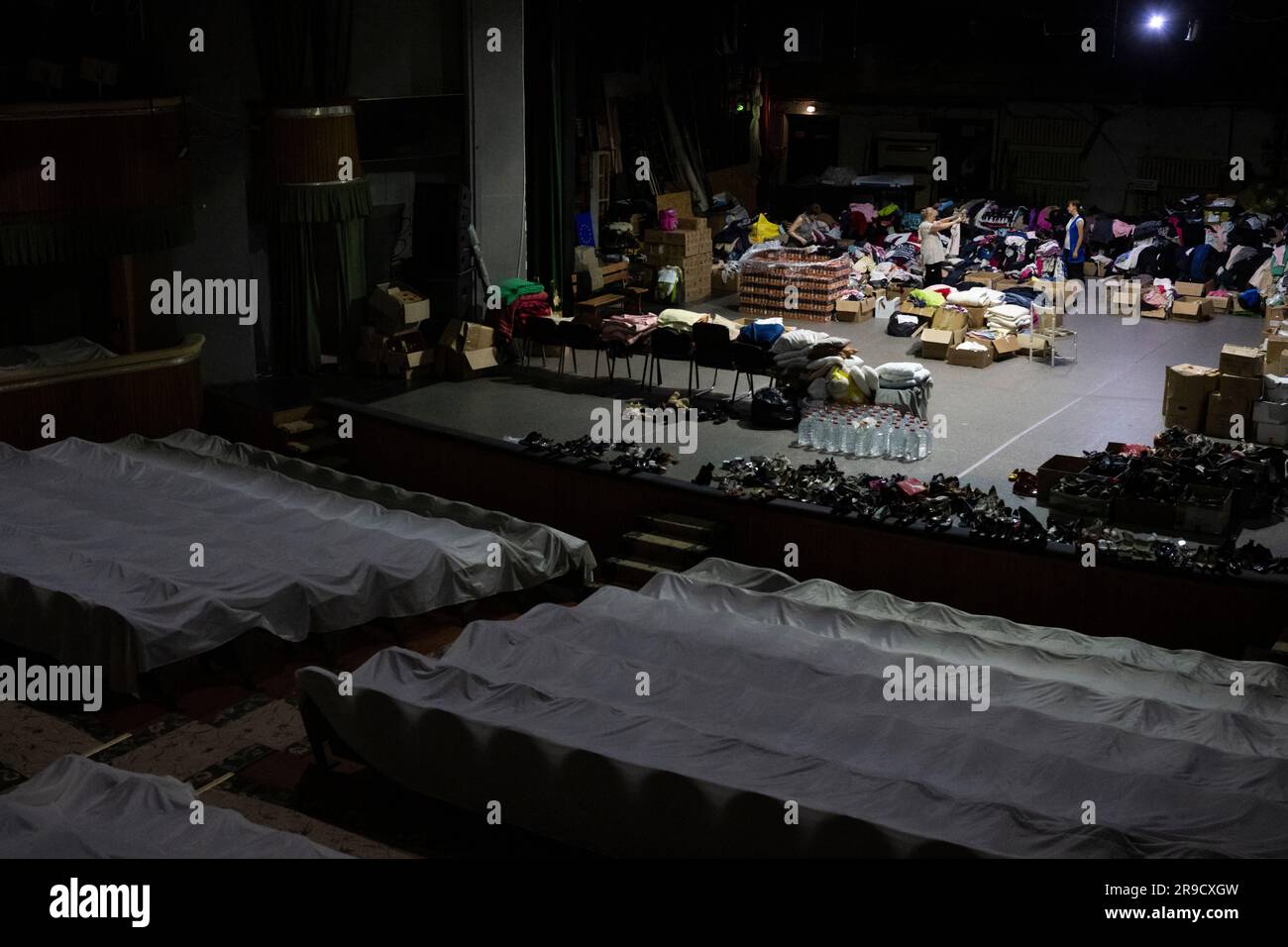 Cherson, Ukraine. 24. Juni 2023. Eine Frau sortierte humanitäre Hilfe für die von der Flut betroffenen Menschen im Kherson Music and Drama Theater von Mykola Kulish in einem Luftschutzbunker in Kherson, Ukraine, am 24. Juni 2023. Der Kakhovka-Staudamm in der Ukraine wurde in den frühen Morgenstunden des 6. Juni 2023 zerstört und verursachte umfangreiche Überschwemmungen entlang des unteren Dnieper-Flusses in der Oblast Kherson. Kredit: Ondrej Deml/CTK Photo/Alamy Live News Stockfoto