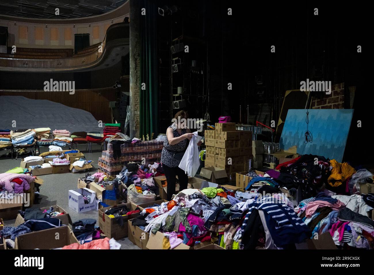Cherson, Ukraine. 24. Juni 2023. Eine Frau sortierte humanitäre Hilfe für die von der Flut betroffenen Menschen im Kherson Music and Drama Theater von Mykola Kulish in einem Luftschutzbunker in Kherson, Ukraine, am 24. Juni 2023. Der Kakhovka-Staudamm in der Ukraine wurde in den frühen Morgenstunden des 6. Juni 2023 zerstört und verursachte umfangreiche Überschwemmungen entlang des unteren Dnieper-Flusses in der Oblast Kherson. Kredit: Ondrej Deml/CTK Photo/Alamy Live News Stockfoto
