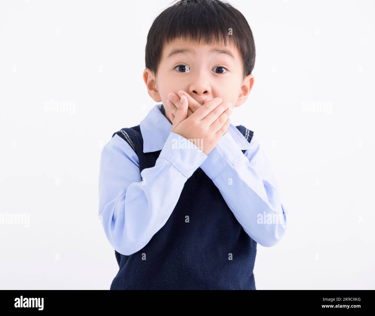 Der kleine Junge schockierte und die Hand bedeckte den Mund wegen eines Fehlers Stockfoto