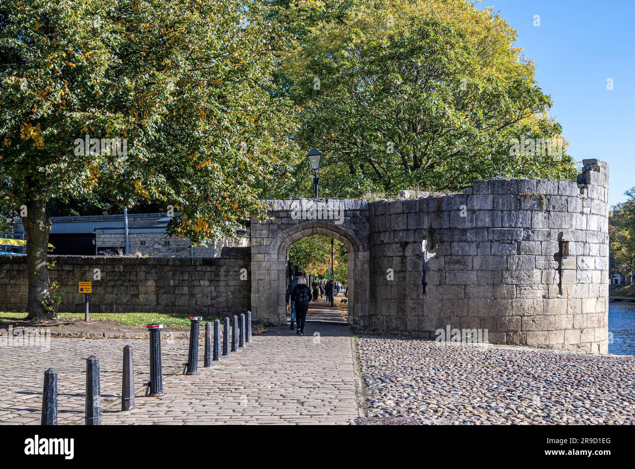 Touristen gehen am Flussufer entlang in der Nähe der Lendal Bridge in York Stockfoto