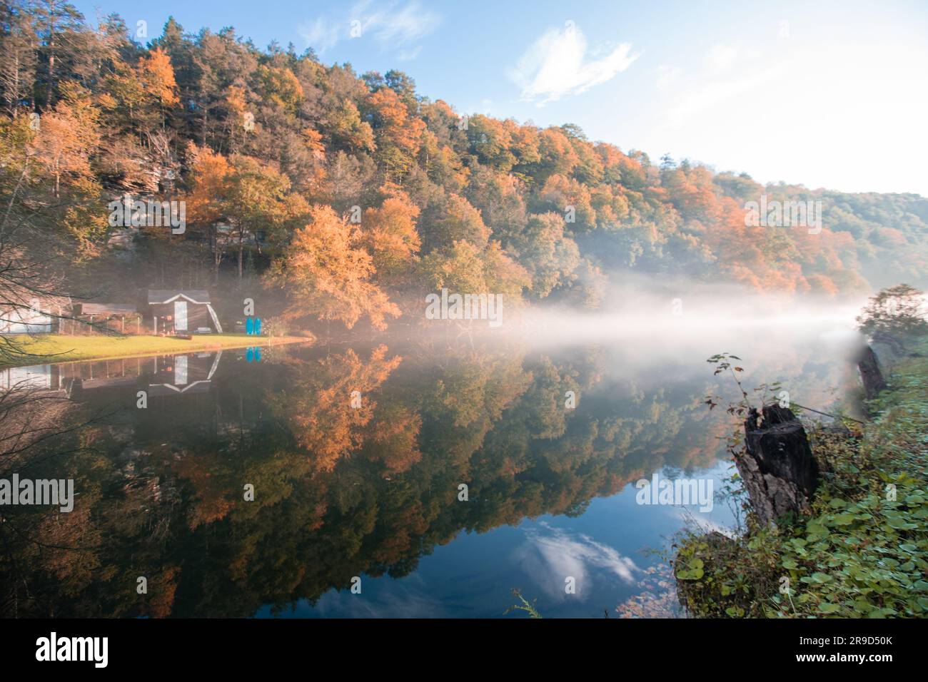 Tief hängender Nebel an einem See mit klarem Himmel im Herbst Stockfoto