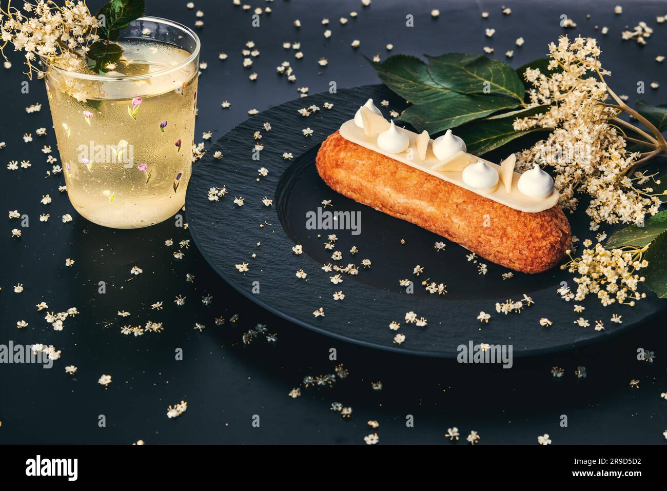 französischer eclair mit Schokolade oder süßen italienischen Profiteroles mit frischem kalten Zwerg-Ältestensaft, süßen, leckeren, frischen Sommercocktail Stockfoto