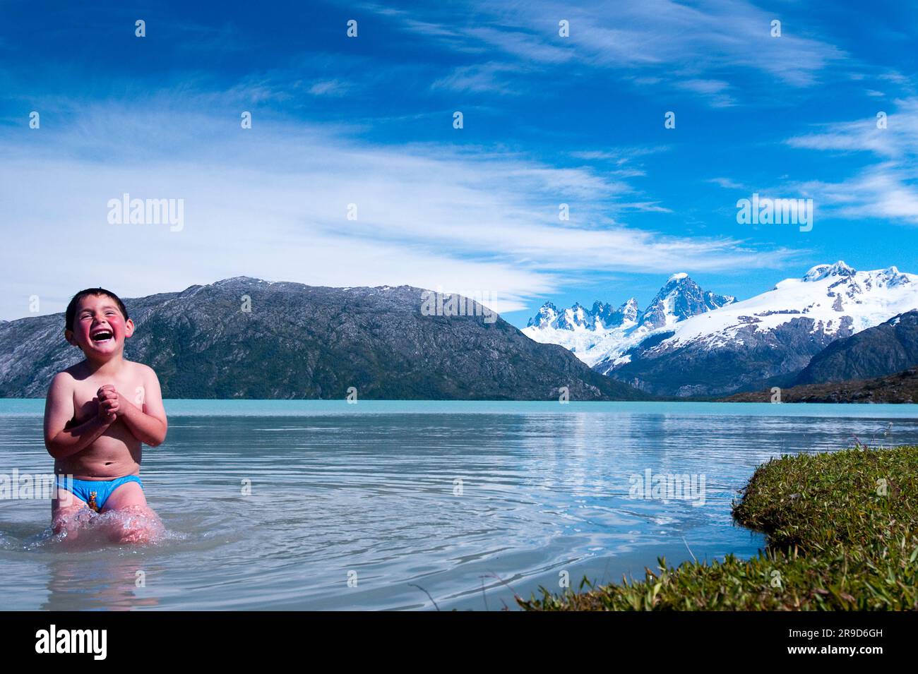 Ein Junge spielt im eisigen Gletscherwasser des Lake O'Higgins, Chile. Stockfoto