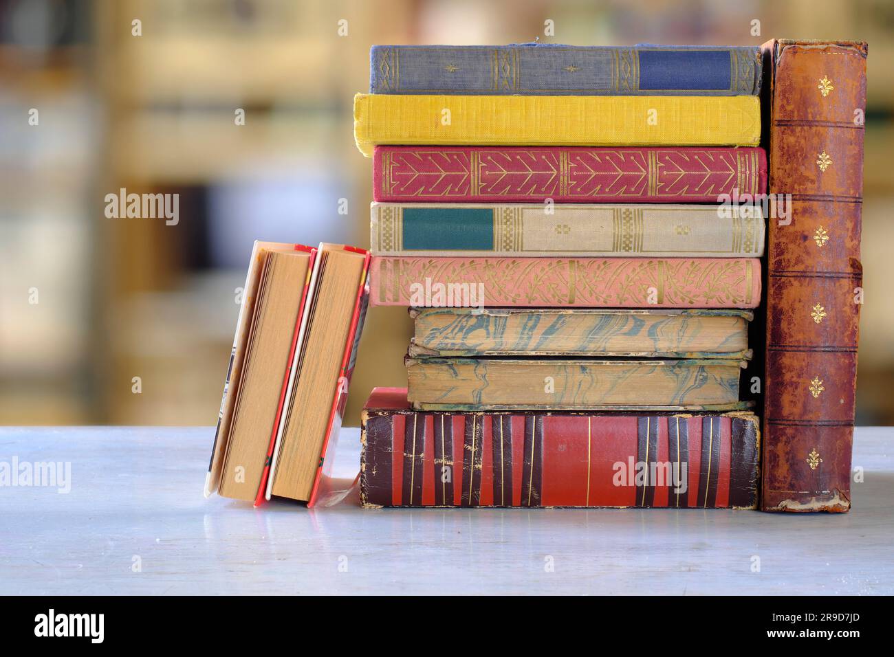 Bücherstapel mit verschwommenem Bücherregal-Hintergrund, Lesen, Lernen, Bildung oder Home-Office-Konzept Stockfoto