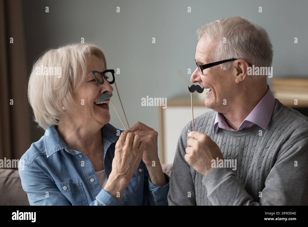 Reife Ehepaare mit lustigen Partyzubehör Stockfoto