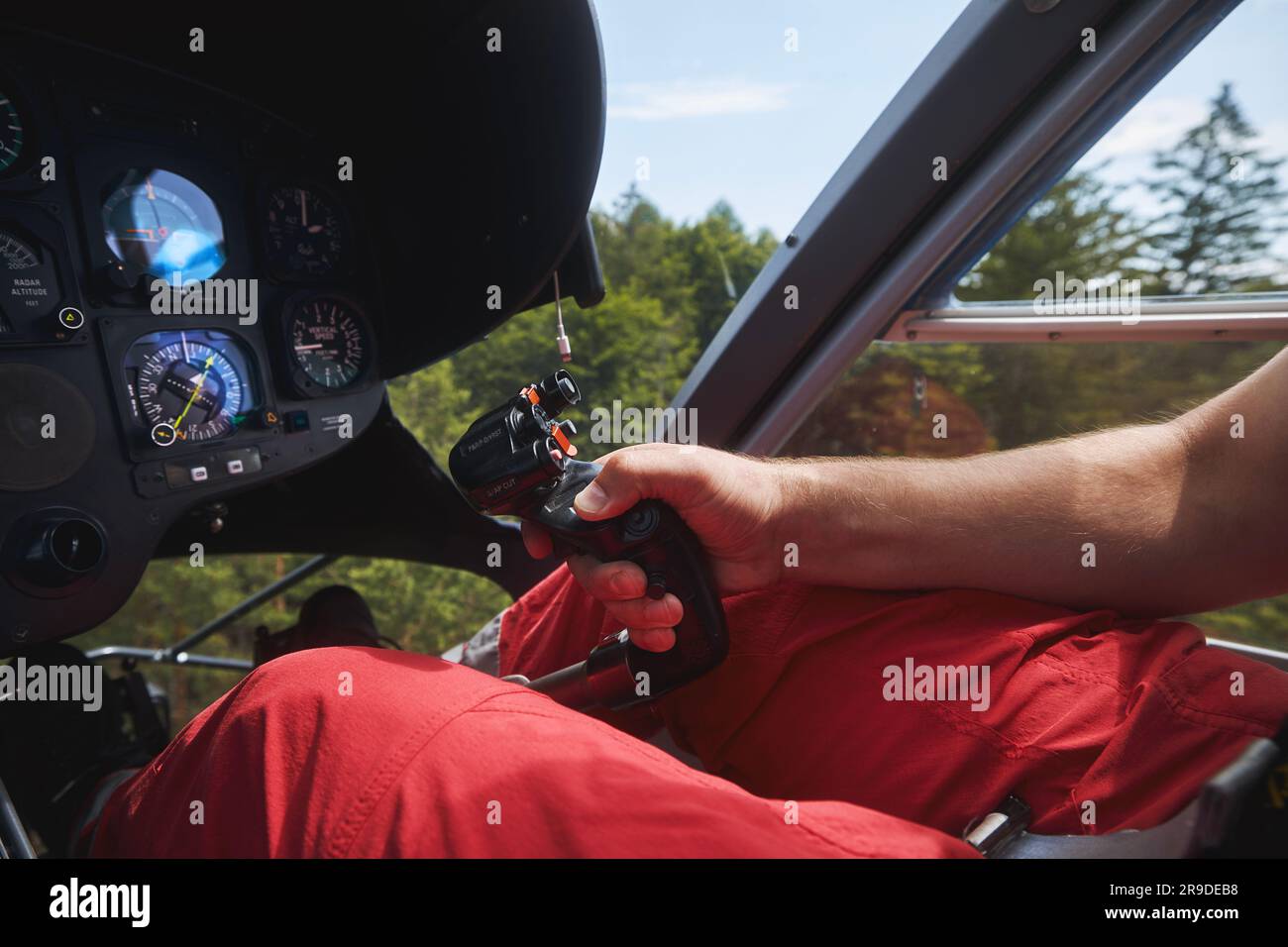 Pilot Helicopter Emergency Medical Service während des Fluges über dem Wald. Nahaufnahme der Flugkontrolle im Cockpit. Stockfoto