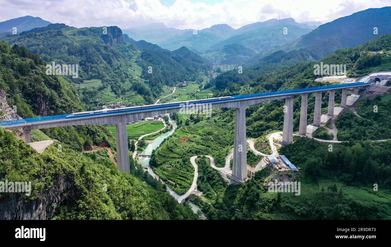 Guiyang, Chinas Provinz Guizhou. 26. Juni 2023. Ein Testzug passiert eine große Brücke in Guiding County, südwestlich Chinas Provinz Guizhou, 26. Juni 2023. Mit der Abfahrt des Testzugs 55311 vom Nordbahnhof Guiyang begann die Hochgeschwindigkeitsbahn Guiyang-Nanning offiziell am Montag mit ihren Betriebstests. Die Eisenbahn verbindet Guiyang in der Provinz Guizhou mit Nanning in der Autonomen Region Guangxi Zhuang mit einer geplanten Geschwindigkeit von 350 km/h. Kredit: Long Jianrui/Xinhua/Alamy Live News Stockfoto