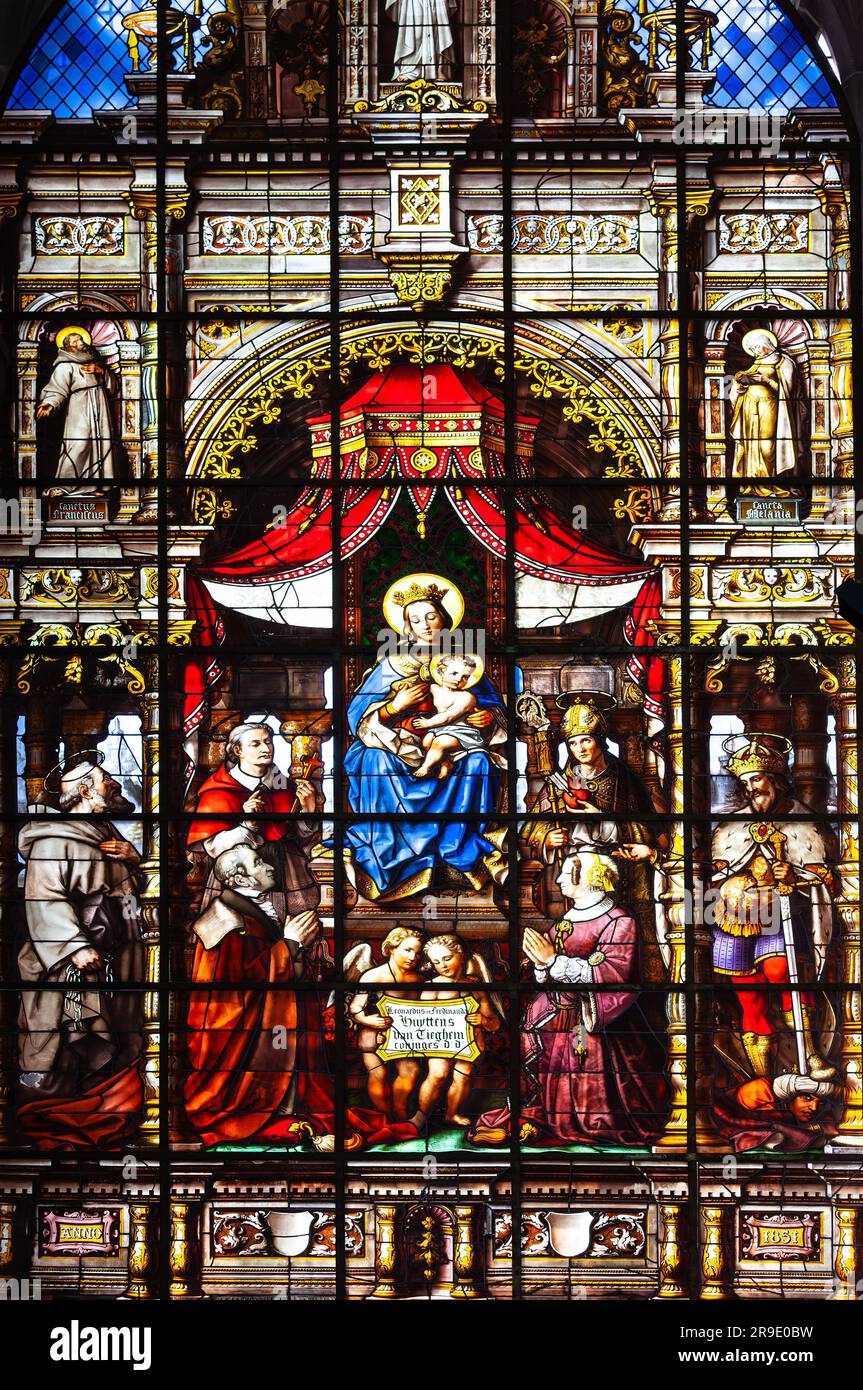 Gent, Belgien - 10. Juli 2010 : Buntglasfenster in der Nikolaikirche. Bild von Maria und Jesus, umgeben von anderen heiligen Menschen. Stockfoto