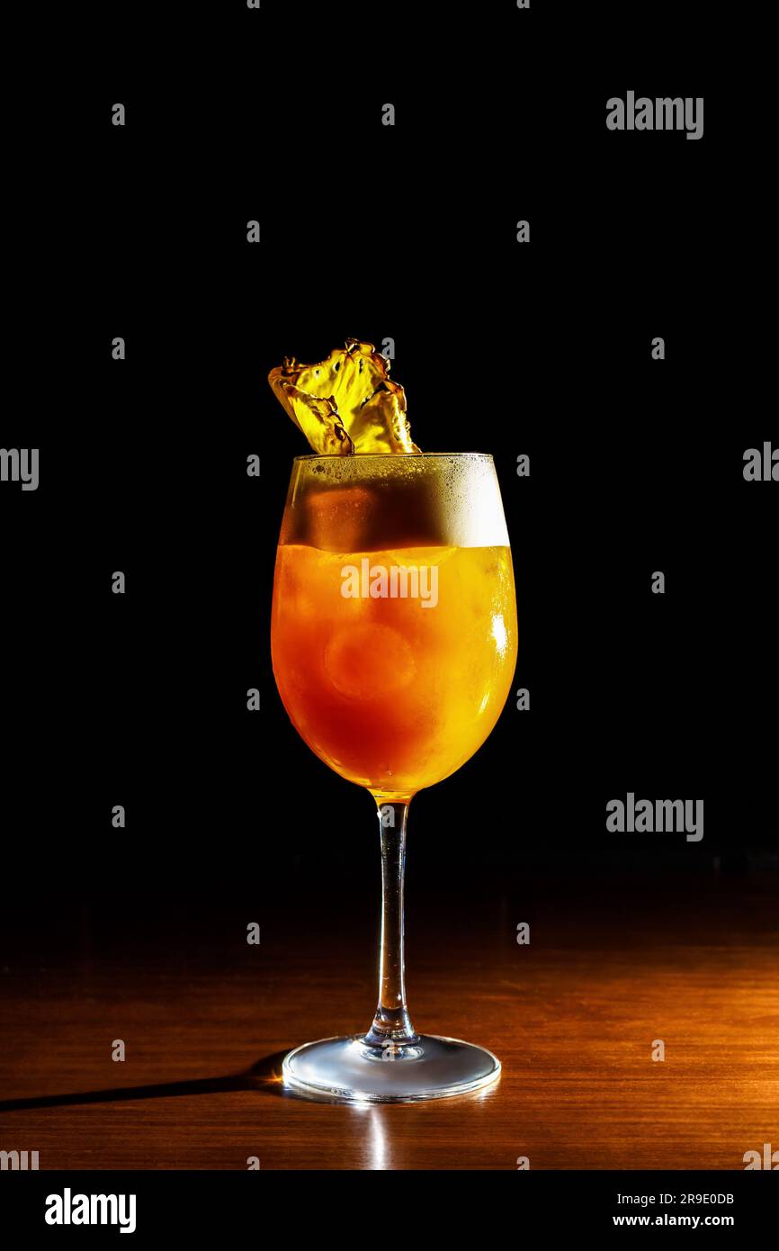 Ein lebhafter gelber Cocktail sitzt einladend in einem Glas drinnen - eine alkoholische Erfrischung, die perfekt für jeden Anlass ist. Stockfoto