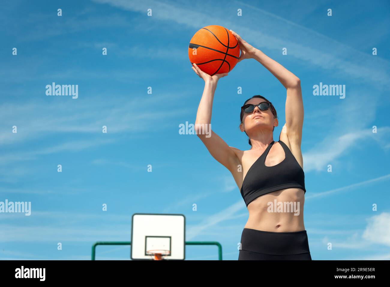 Stylische, fit Frau beim Basketballspielen. Stockfoto