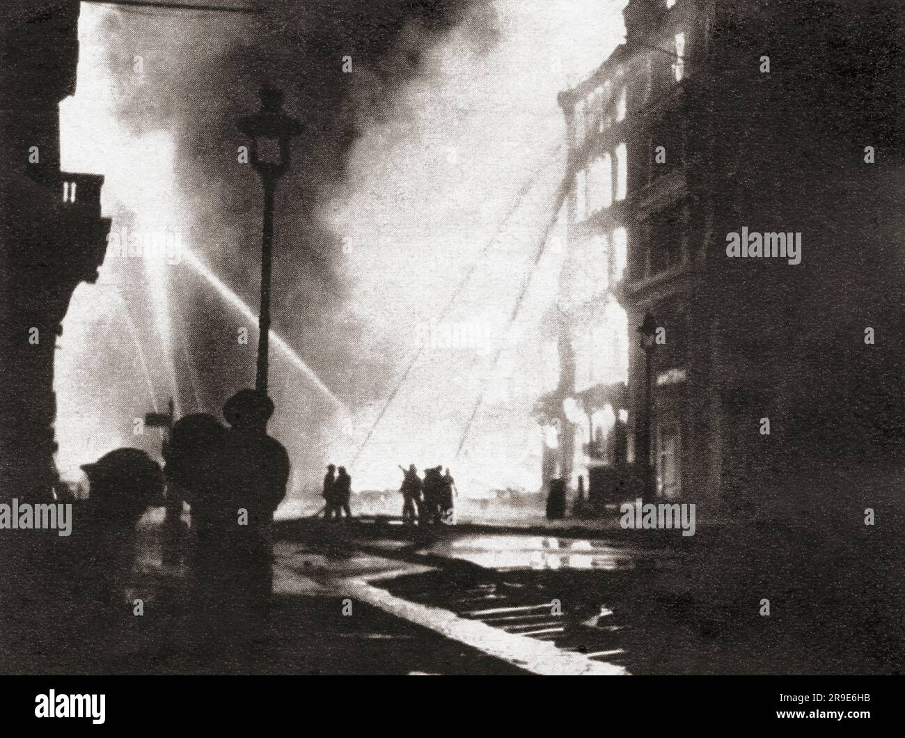 Feuerwehrmänner, die Feuer bekämpfen, die durch Feuerbomben verursacht wurden, die in Eastcheap auf städtische Unternehmen fielen, 11. Januar 1941 während des Zweiten Weltkriegs. Von Front Line 1940-41, veröffentlicht 1942 Stockfoto