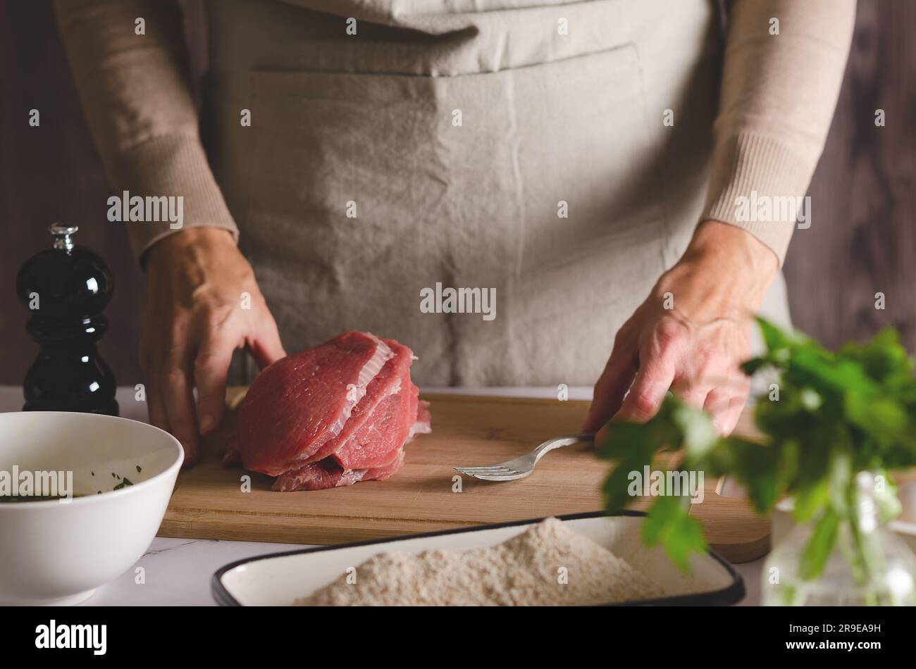 Nahaufnahme der Hände einer Frau, die bereit ist, argentinische Milanesas vorzubereiten. Stockfoto