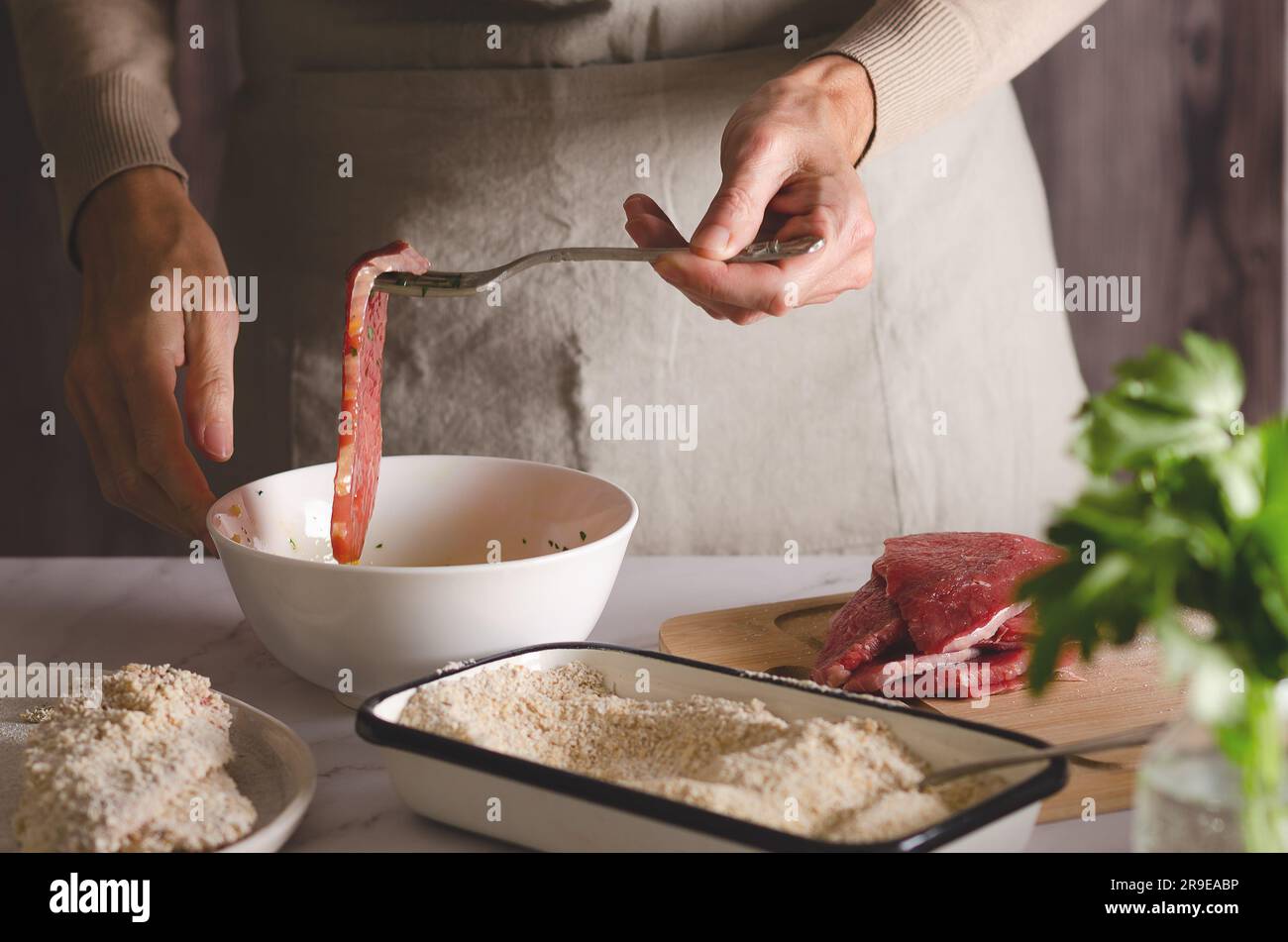 Nahaufnahme von weiblichen Händen, die argentinische Milanesas in der Küche zu Hause kochen. Stockfoto