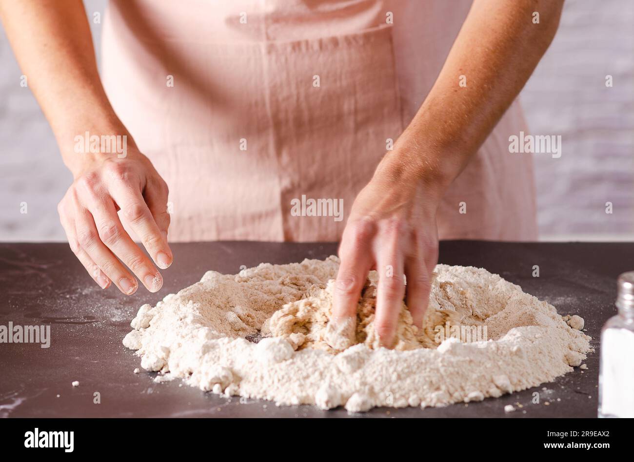 Weibliche Hände kneten Teig in der Küche, Nahaufnahme. Kochprozess. Stockfoto