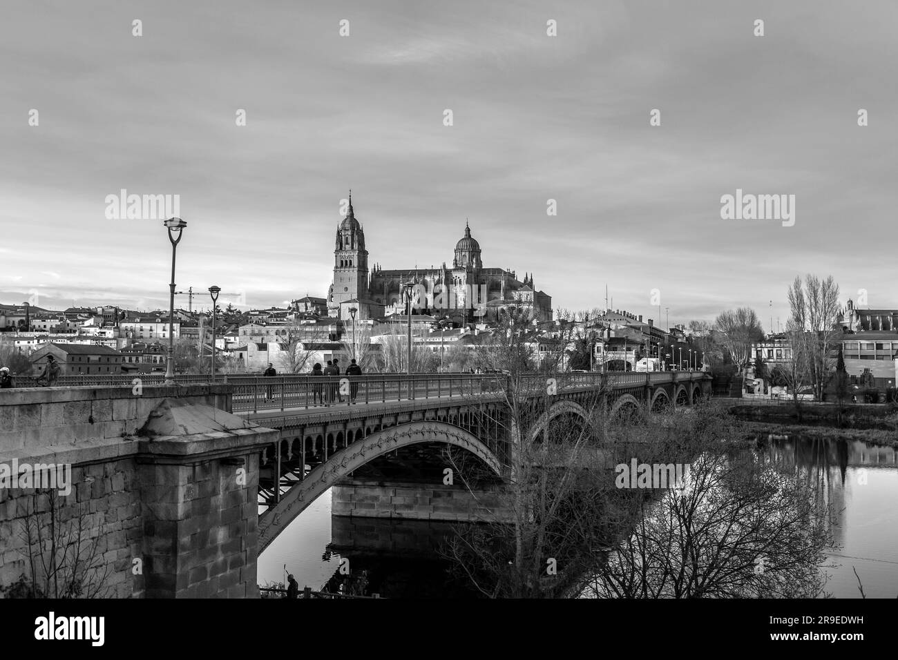 Salamanca, Spanien - 20. Februar 2022: Blick auf die Skyline von Salamanca mit Kathedrale und Enrique-Estevan-Brücke am Tormes River bei herrlichem Sonnenuntergang. Stockfoto